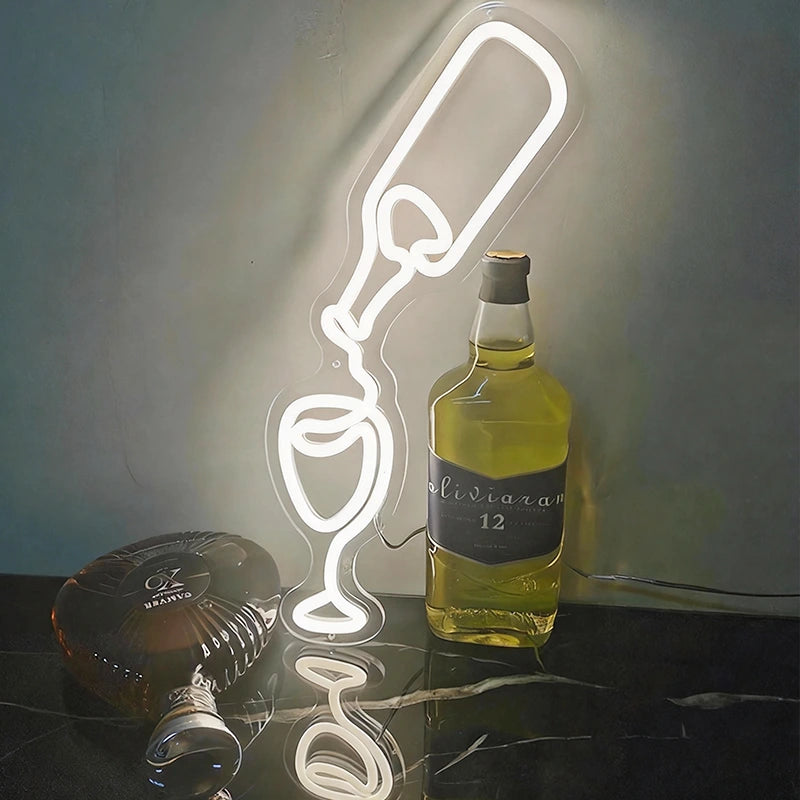 Neon light shaped like a wine bottle and glass on a reflective surface with bottles in the background.