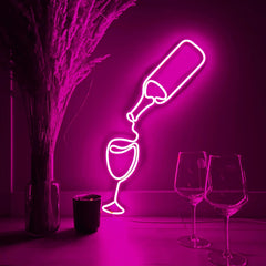 Hot pink neon light shaped like a wine bottle and glasses on a dark background