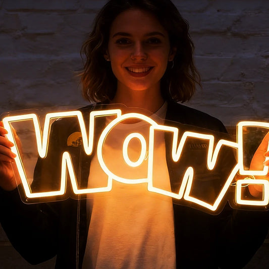 Person holding a 'WOW!' sign with neon lights against a dark background