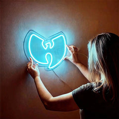 Person holding a neon Wu-Tang Clan logo against an ice blue background