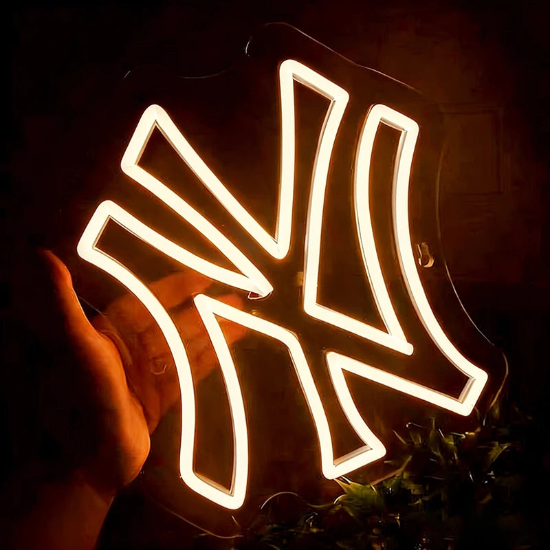 Neon warm white light with yankees logo, held by a hand against a dark background
