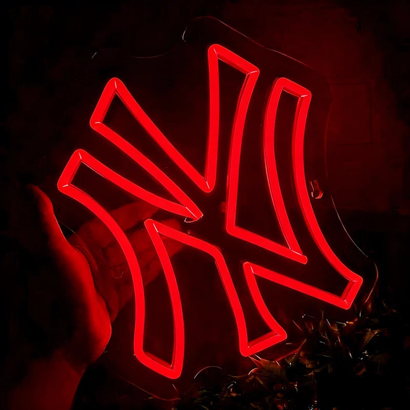 Neon red light with yankees logo, held by a hand against a dark background