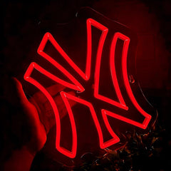 Neon red light with yankees logo, held by a hand against a dark background