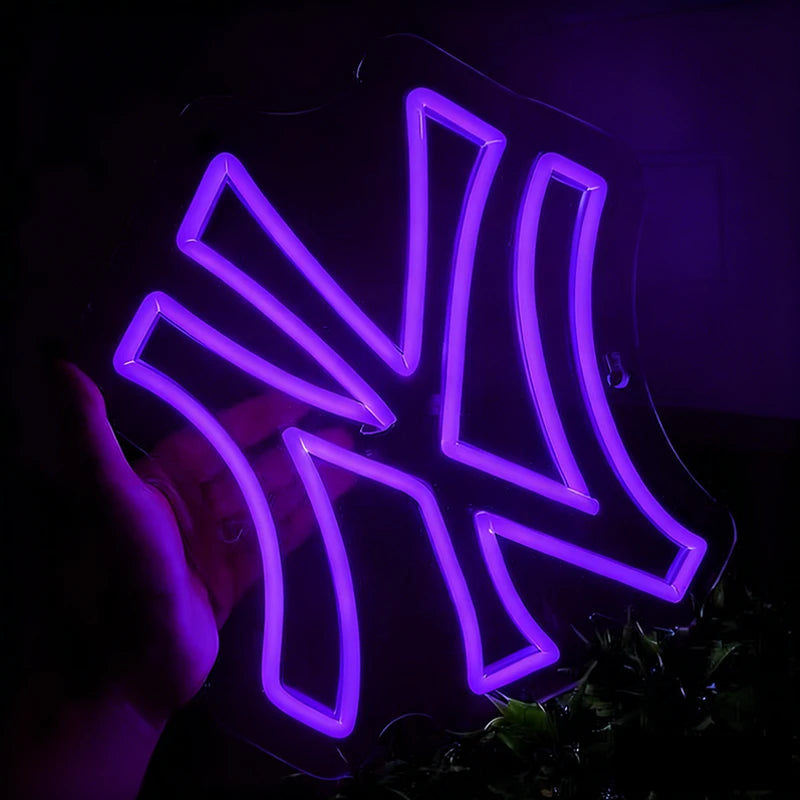 Neon sign shaped like a yankees logo with a purple glow on a dark background