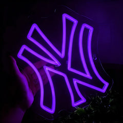 Neon sign shaped like a yankees logo with a purple glow on a dark background