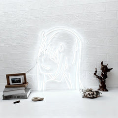 Neon light shaped like zero two on a white textured wall with decorative items below.