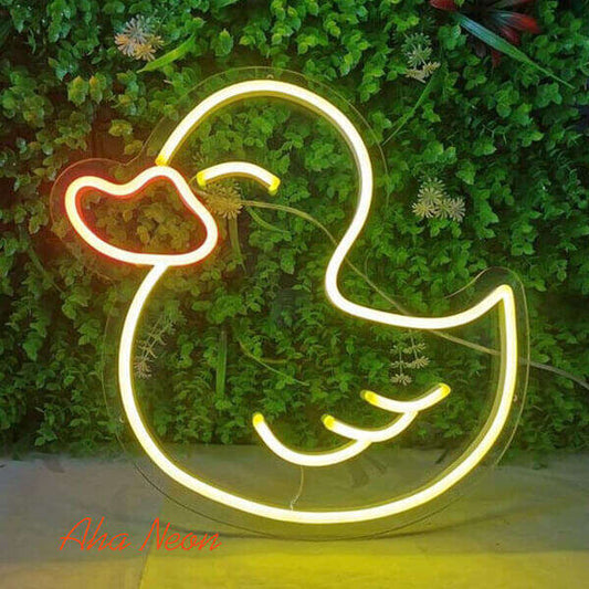 Neon duck sign on a green leafy background with 'Aha Neon' branding.