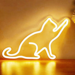 Neon cat-shaped lemon yellow light on a wooden surface with a warm glow