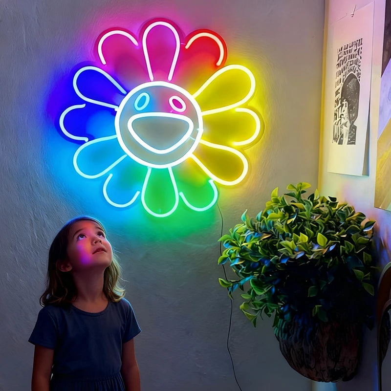 Child looking up at a colorful flower-shaped neon light on a wall.