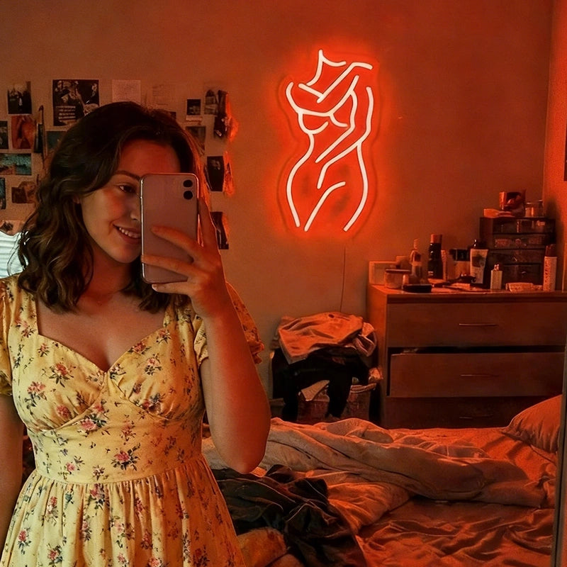 Neon sign of a woman on a wall in a bathroom with red lighting.