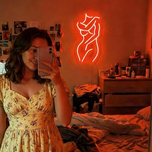 Neon sign of a woman on a wall in a bathroom with red lighting.